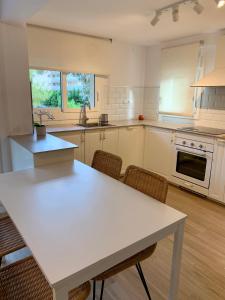 een grote keuken met een witte tafel en stoelen bij Be-Cool Salou pool center in Salou