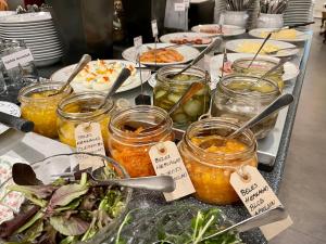 a buffet of food with jars of pickles and vegetables at Hotell Bele in Trollhättan