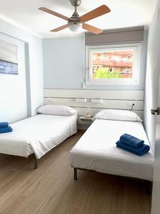 2 bedden in een kamer met een plafondventilator bij Be-Cool Salou pool center in Salou
