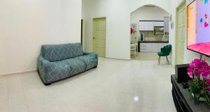 uma sala de estar com um sofá e uma cozinha em Nurul Amin Guest House Pantai Cahaya Bulan Kota Bharu em Kota Bharu