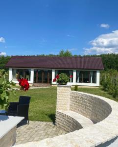 a house with a stone wall and a patio at Pensiunea Ivoire in Avrig