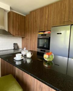 a kitchen with a black counter top with a refrigerator at Pensiunea Ivoire in Avrig