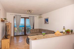 ein Wohnzimmer mit einem Sofa und einem Tisch in der Unterkunft Apartments Lacic 2 in Crikvenica