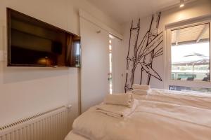 Schlafzimmer mit einem Flachbild-TV an der Wand in der Unterkunft Plitvice Holiday Resort in Grabovac