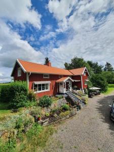 una casa roja con una entrada delante de ella en Pilakvarn en Falköping