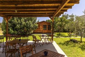 un patio con tavoli e sedie sotto un padiglione in legno di Tenuta La Chianca a Matino