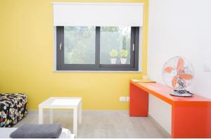 a room with a desk with a fan and a window at La Casa del Riccio in Tindari