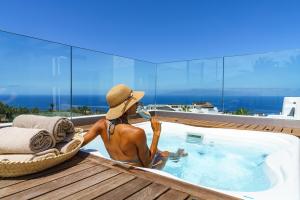 a statue of a woman in a hat sitting next to a swimming pool at Las Terrazas de Abama Suites in Guía de Isora