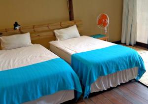 dos camas sentadas una al lado de la otra en una habitación en Underwater Explorer en Ponta do Ouro
