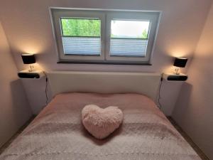 a bedroom with a heart shaped pillow on a bed at Ferienwohnung Los Liebos in Fürth