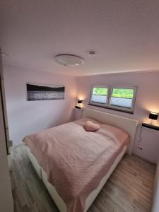 a bedroom with a bed and two windows at Ferienwohnung Los Liebos in Fürth