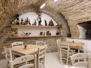 a dining room with two tables and white chairs at Villa Alta Langa in Cravanzana