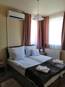 Un pat sau paturi într-o cameră la Bacchus Vendégház