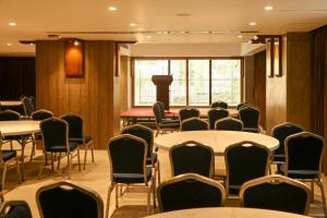 una sala de conferencias con mesas, sillas y una ventana en Pearl Harbour Business Hotel en Chittagong