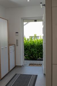 einen Flur mit offener Tür zum Aartmentartment in der Unterkunft Twins Apartman Hévíz in Hévíz