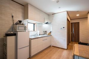 鐮倉的住宿－KAMAKURA DEL COSTA，厨房配有白色冰箱和微波炉