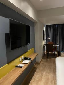 a hotel room with a large flat screen tv on the wall at The Quarter Ladprao by UHG in Bangkok