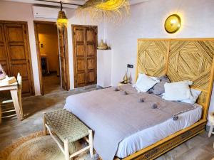 a bedroom with a large bed with a wooden headboard at Riad Dar Chadia in Marrakesh
