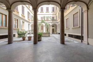 an empty courtyard with columns in a building at Milan Retreats Duomo Suites in Milan