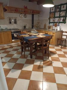 a kitchen with a table and chairs on a checkered floor at Casa Mali in Cres +21 photos