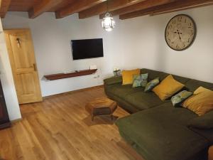 a living room with a couch and a clock on the wall at Casa Mali in Cres