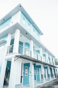 a white and blue building with a balcony at Lee Residences by JAL in Legazpi