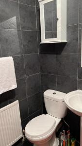 a bathroom with a white toilet and a sink at Smalinz Homes Finchley in London