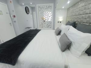 um quarto com uma grande cama branca e uma janela em Casa Rua Velha em Horta