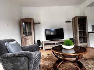 a living room with two chairs and a table and a television at Sarah's Zugspitz Inn in Garmisch-Partenkirchen +8 photos