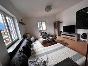 a living room with a couch and a tv at Sarah's Zugspitz Inn in Garmisch-Partenkirchen
