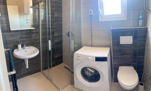 łazienka z pralką i umywalką w obiekcie Daniela Family Apartment - top floor - new & quite location - great sea & island view w mieście Vir