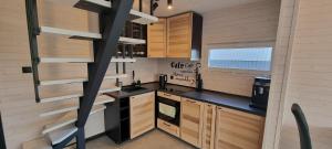 a kitchen with wooden cabinets and a spiral staircase at Level780 in Koszarawa