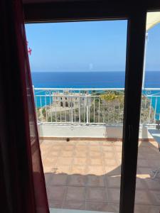 a view of the ocean from a sliding glass door at BlueMind in Tropea