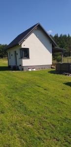 a white house with a large field of grass at Wierzchy 34 in Wierzchy