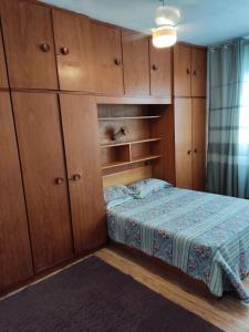 Dormitorio pequeño con cama y armarios de madera en Condominio Barra Sul - Edifício Marapendí, en Río de Janeiro