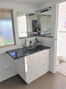 a bathroom with a sink and a person in a mirror at Chill at our Igloo cottage - 100m stroll to beach in Portarlington +12 photos