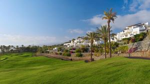 a golf course with palm trees and condos at Las Terrazas de Abama Suites in Guía de Isora