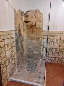 a shower in a bathroom with a stone wall at La Casa di Cofano in Custonaci