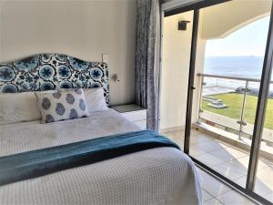 405 Bermudas - by Stay in Umhlanga في ديربان: غرفة نوم مع سرير وإطلالة على المحيط