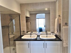 a bathroom with two sinks and a shower at 405 Bermudas - by Stay in Umhlanga in Durban