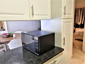 a microwave sitting on top of a counter in a kitchen at 405 Bermudas - by Stay in Umhlanga in Durban