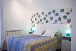 a bedroom with a bed with a floral wallpaper at Quintana 23 in Suances