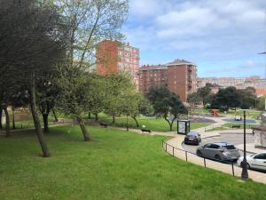 ein Park mit Autos auf dem Rasen und in Gebäuden in der Unterkunft Apartamento Santander in Santander