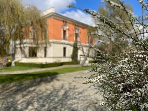 een groot bakstenen huis met witte bloemen ervoor bij Happy Living Villa in Wrocław