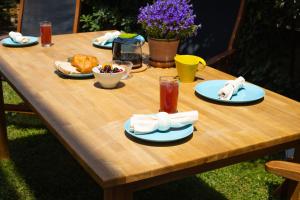 une table en bois avec des assiettes de nourriture dans l'établissement Relaxing family house with garden in Avra, Rafina, à Rafína