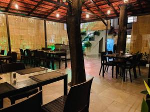 a restaurant with tables and chairs in a room at Shivanand Residency in Jejūri