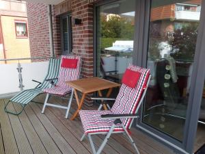 two chairs and a table on a porch at Ferienwohnung "Strandläufer 1" in Böhl