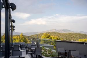 a balcony with tables and chairs and mountains in the background at Moro Inn in Korčula