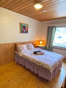 a bedroom with a bed and a large window at Home with private garden near golf, beach, fishing in Hartola