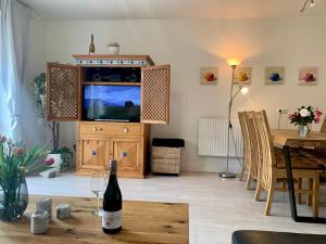 uma sala de estar com uma garrafa de vinho numa mesa em Ferienhaus RH "Strandkieker Middenmang" em Sankt Peter-Ording